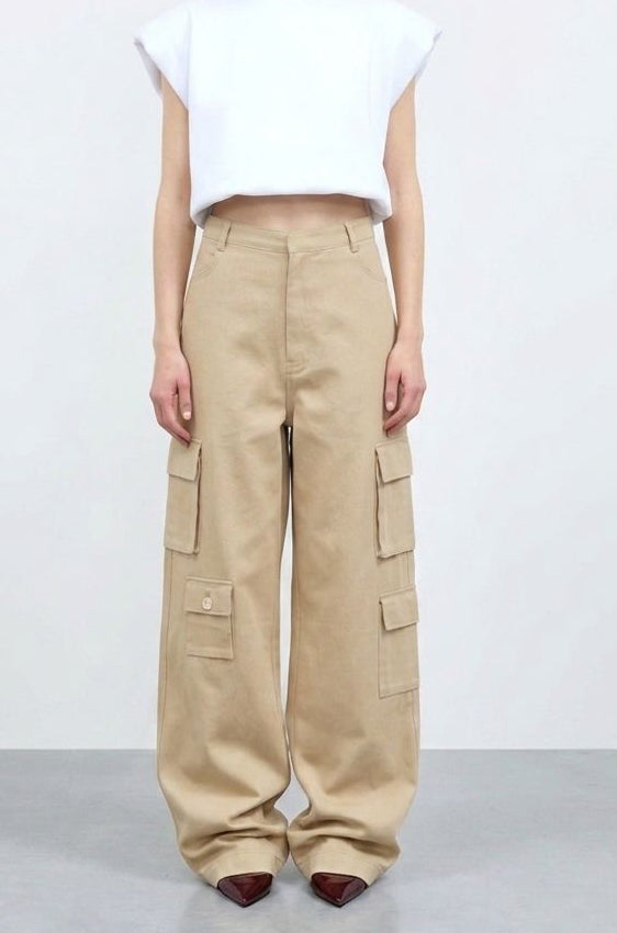 Person wearing a white top and beige cargo pants on a plain background