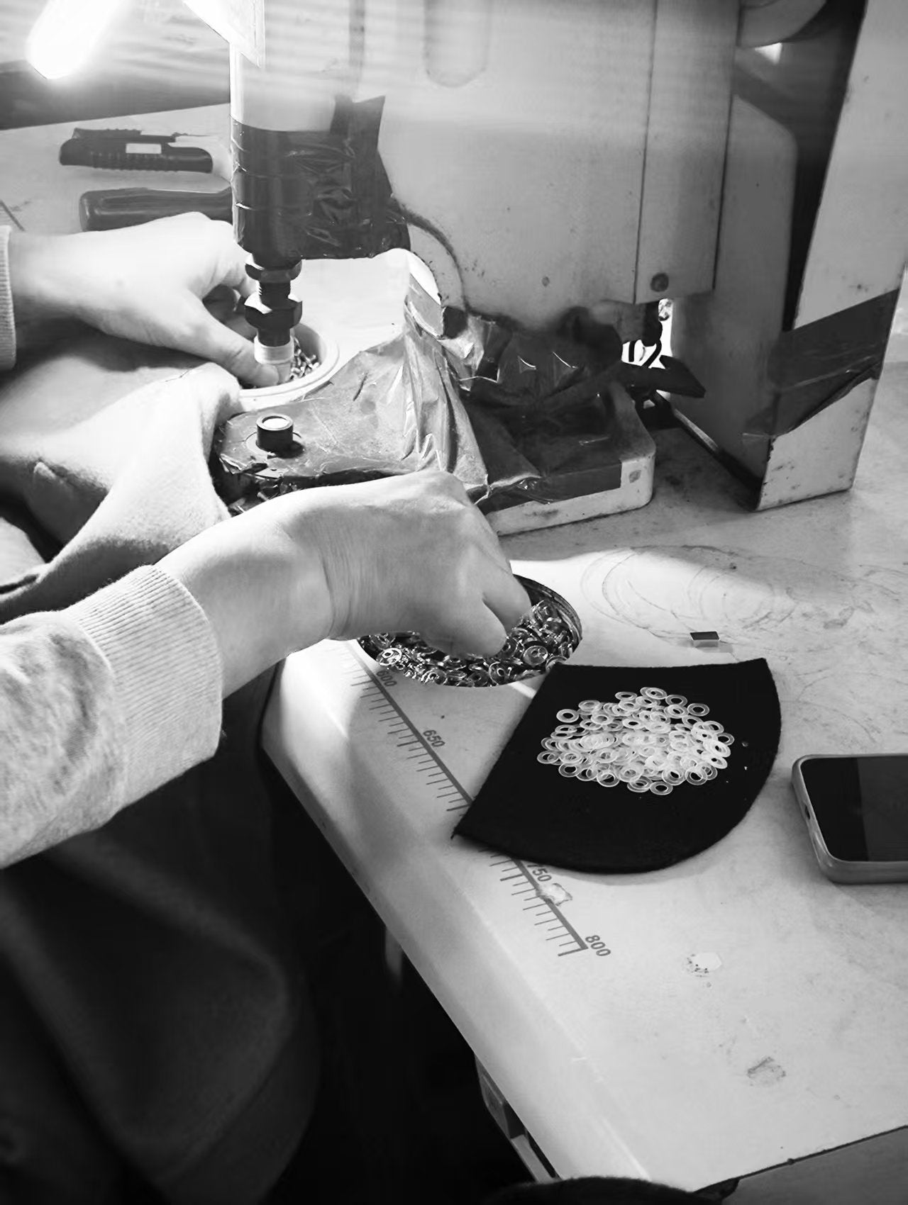 Rhúne atelier — artisan hands crafting garments with precision and care in Belgian production workshop