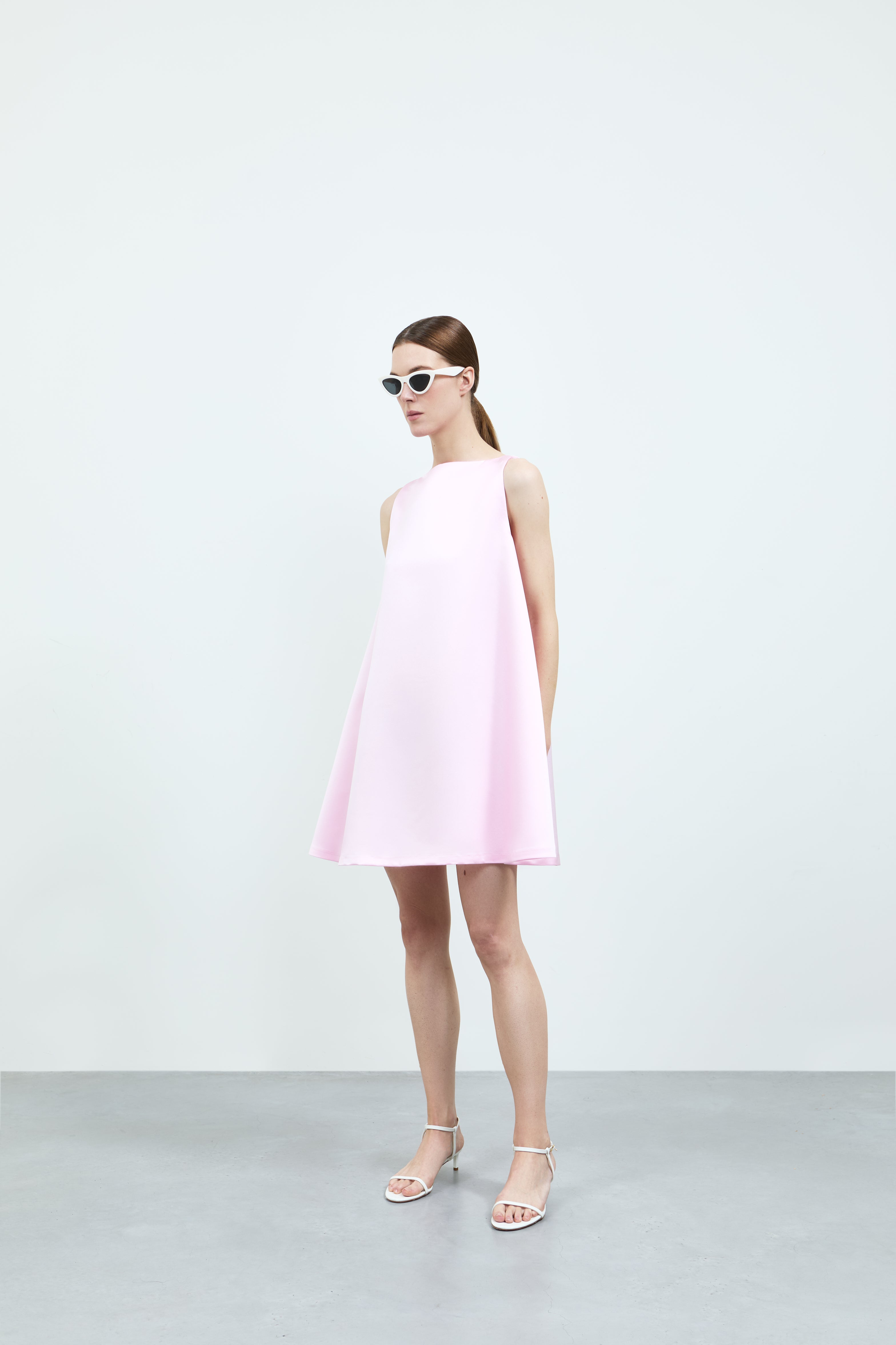 Woman wearing a pink dress against a white background