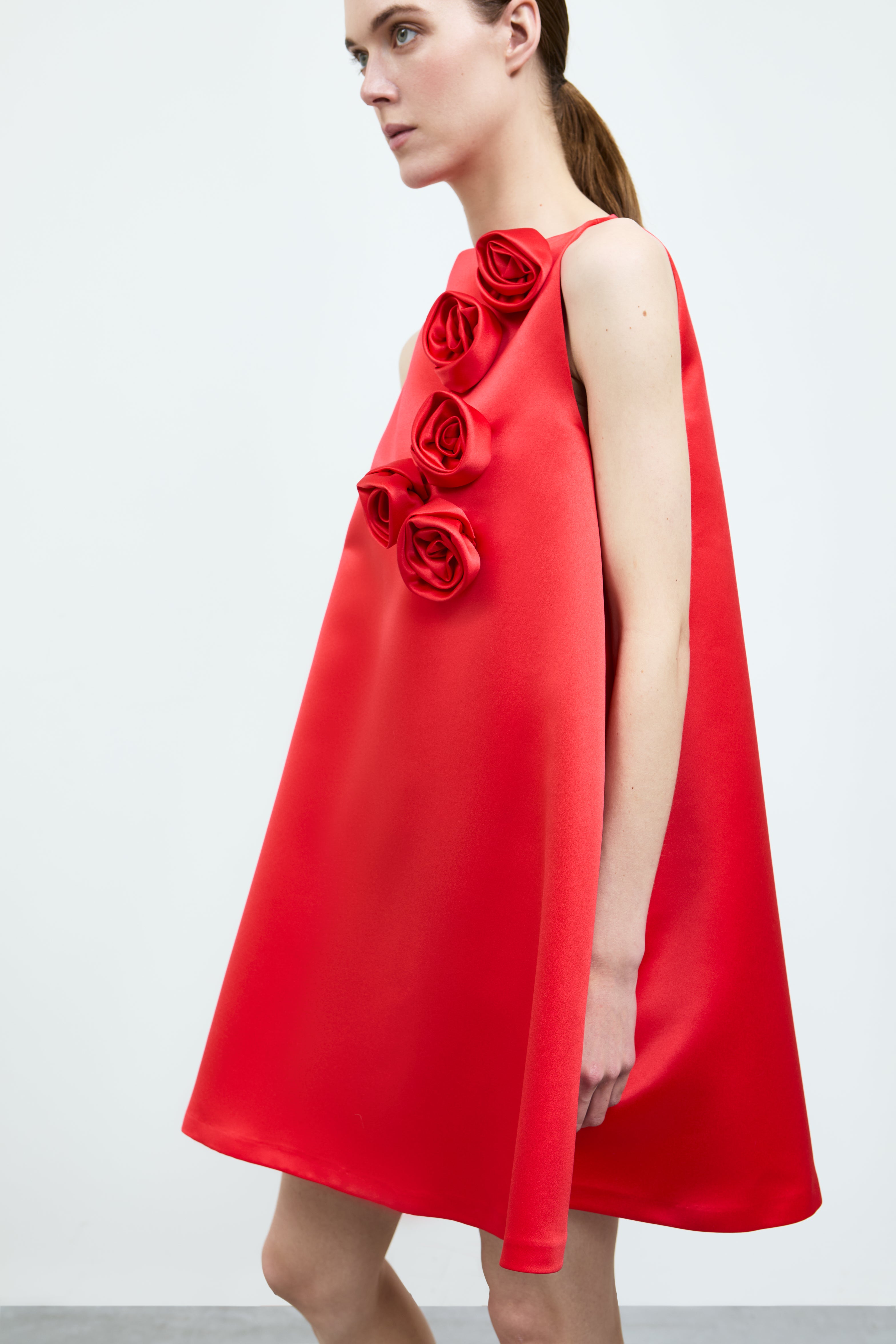 Red dress with floral embellishments on a white background