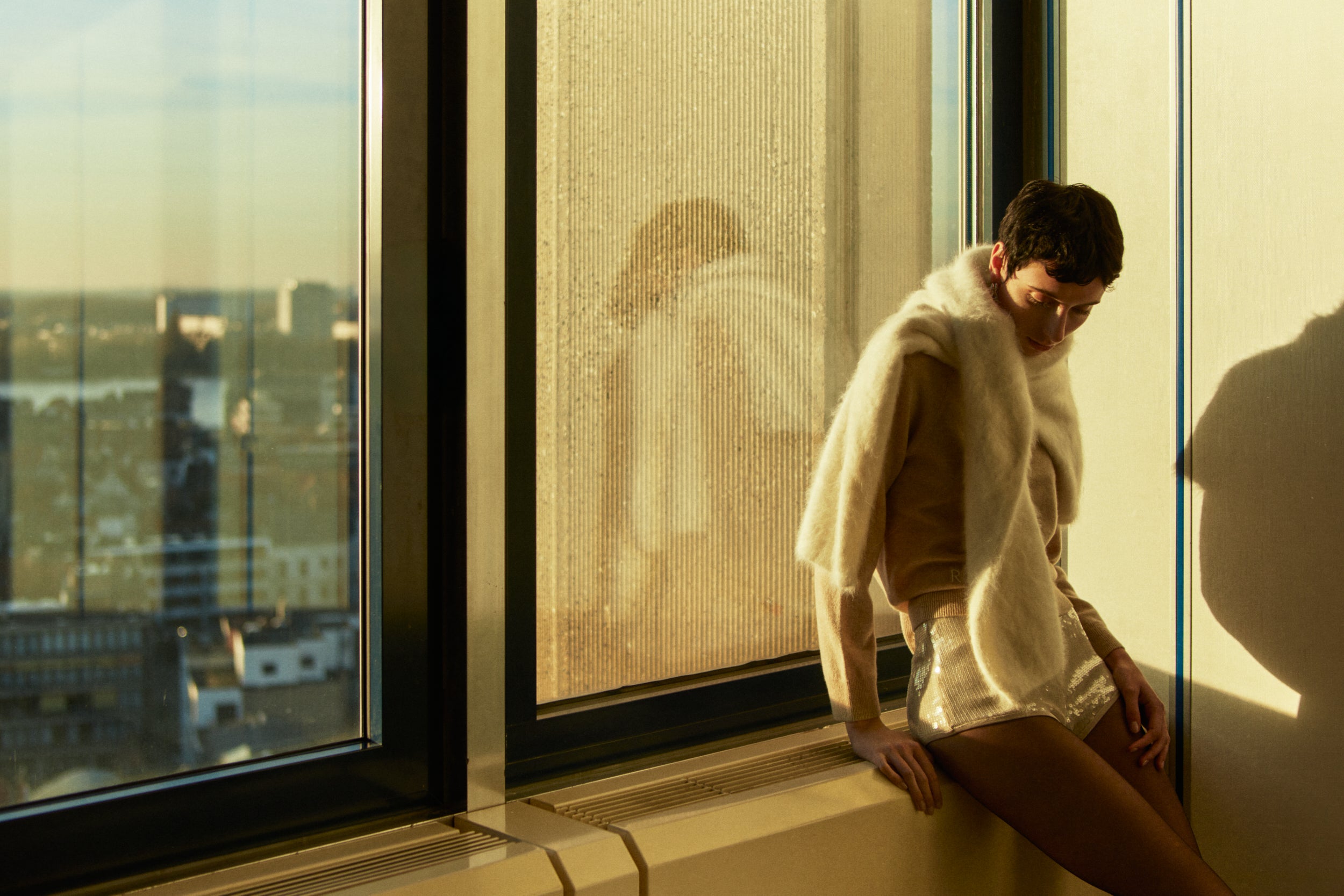 Rhúne AW25 campaign — soft cashmere layers and sculptural knitwear bathed in golden light