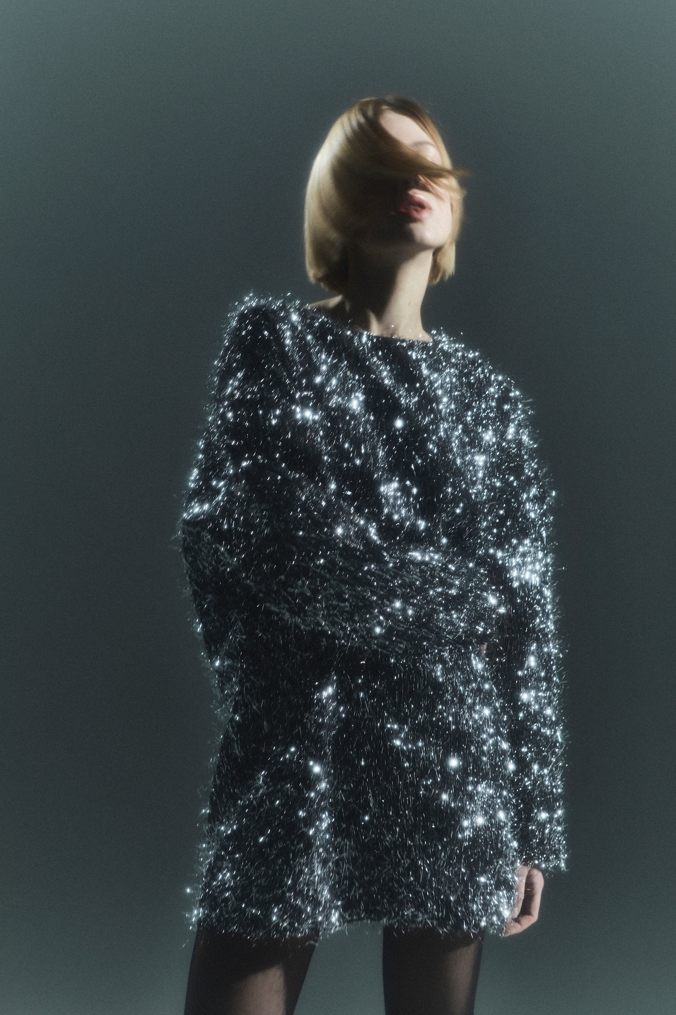 Rhúne AW24 campaign — silver sequin dress evoking movement and light