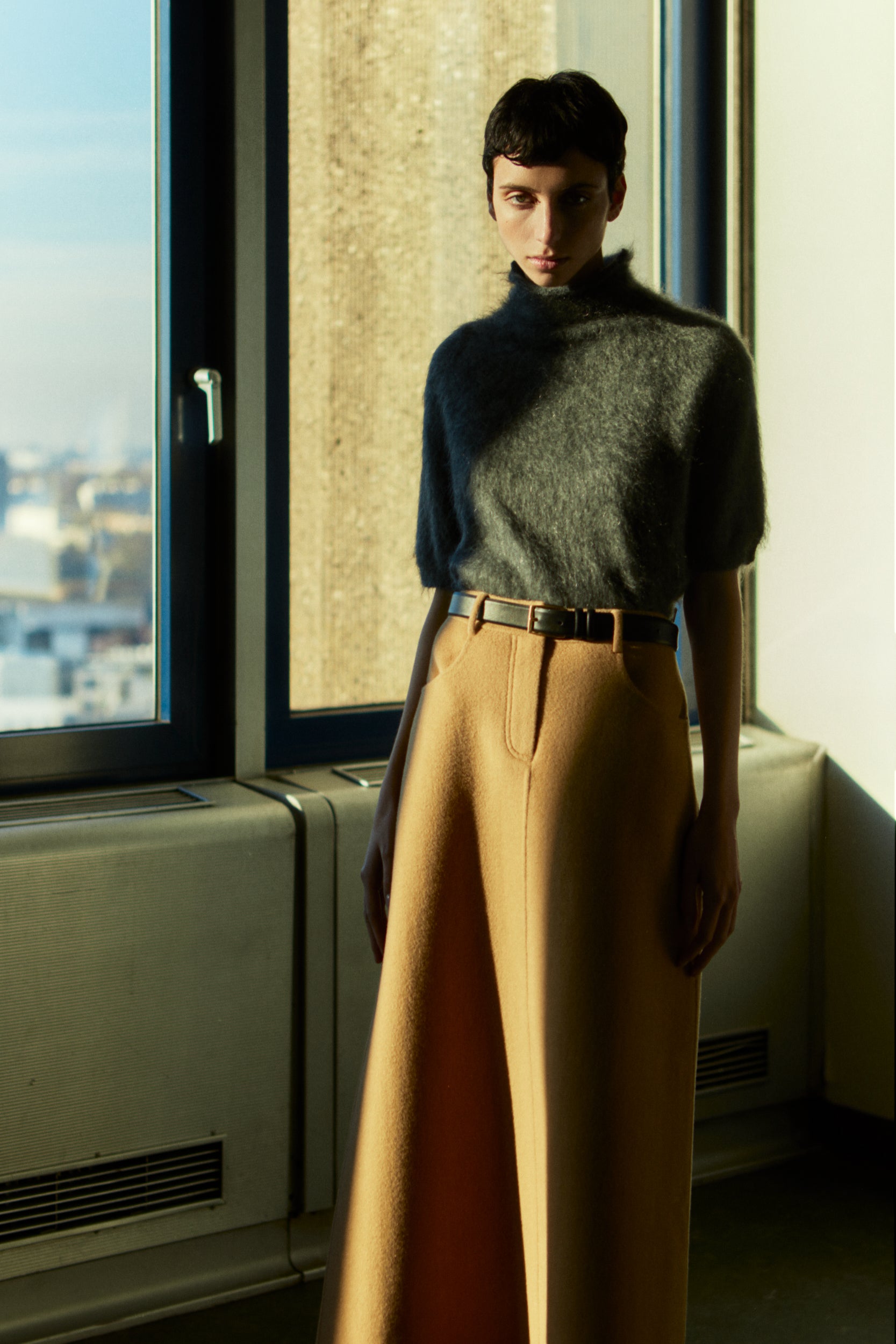 Rhúne AW25 Elisabeth Knit in grey paired with Nel Skirt in camel — refined wool look in soft golden light