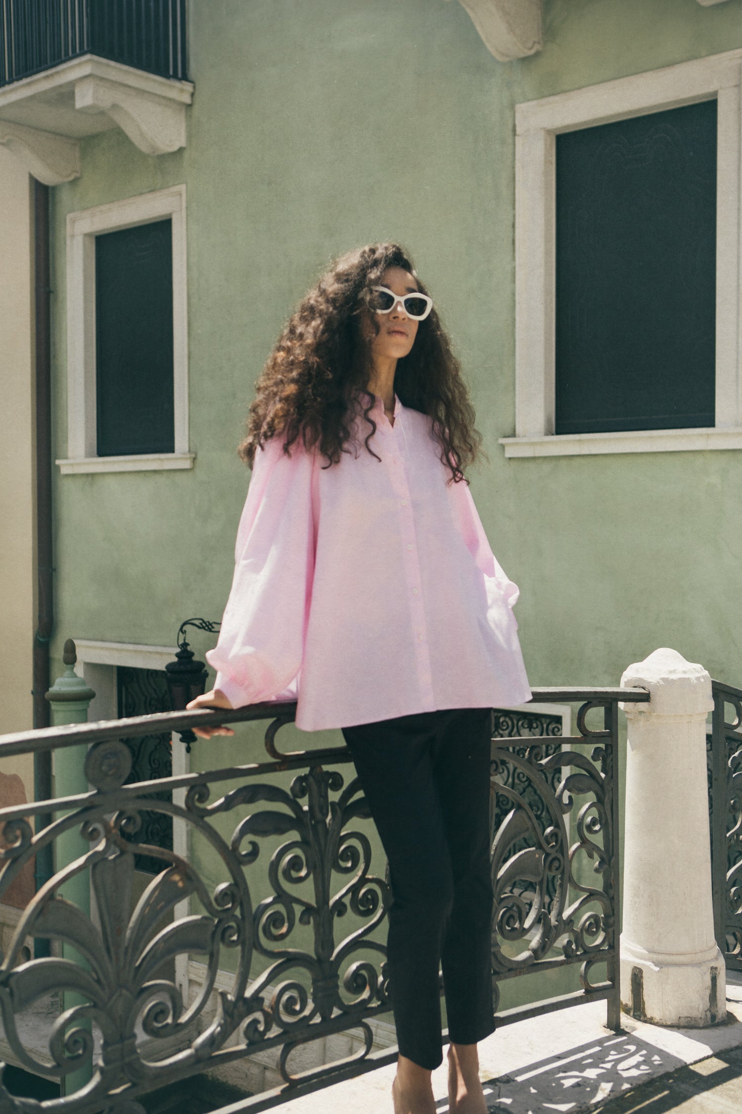 Rhúne SS24 collection — pink silk blouse styled on a Venetian bridge under soft daylight
