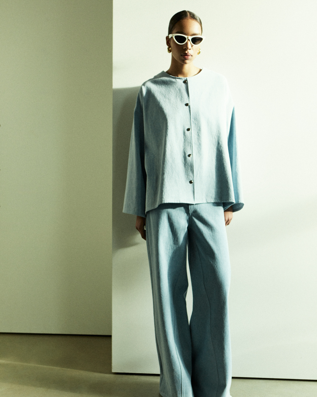 Rhúne SS25 campaign — light blue oversized shirt and wide trousers styled with modern elegance